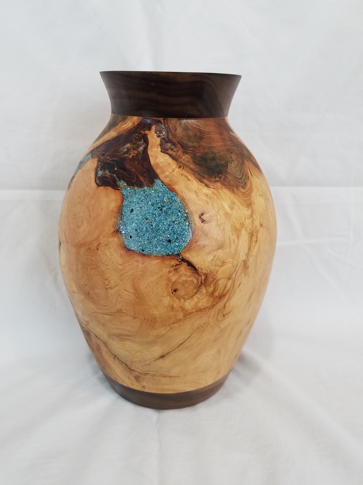 Pine burl found in a firewood pile.  Turned on a lathe and inlayed with colored epoxy. 